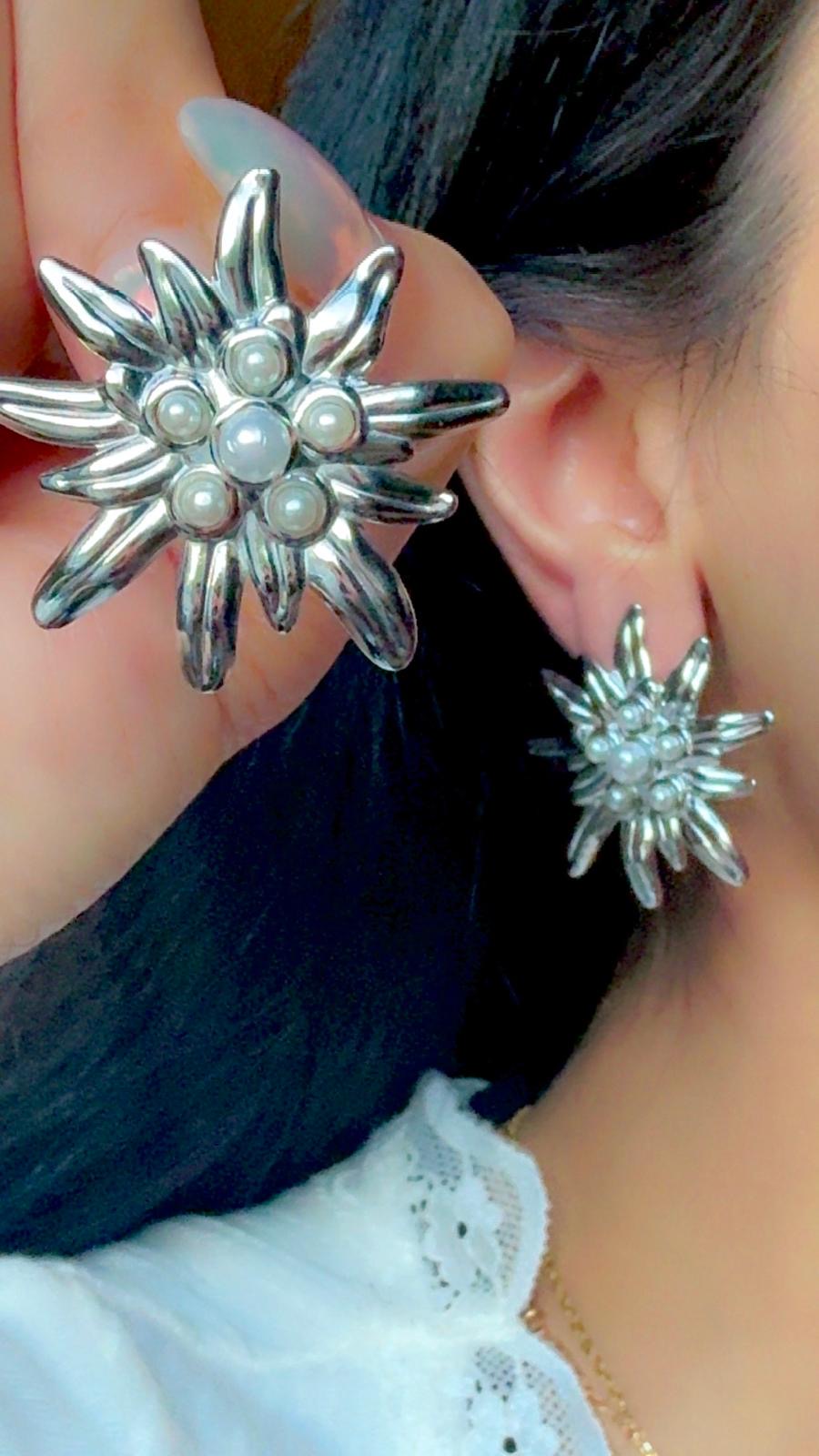 Silver flower statement earrings with pearl accents displayed on ear