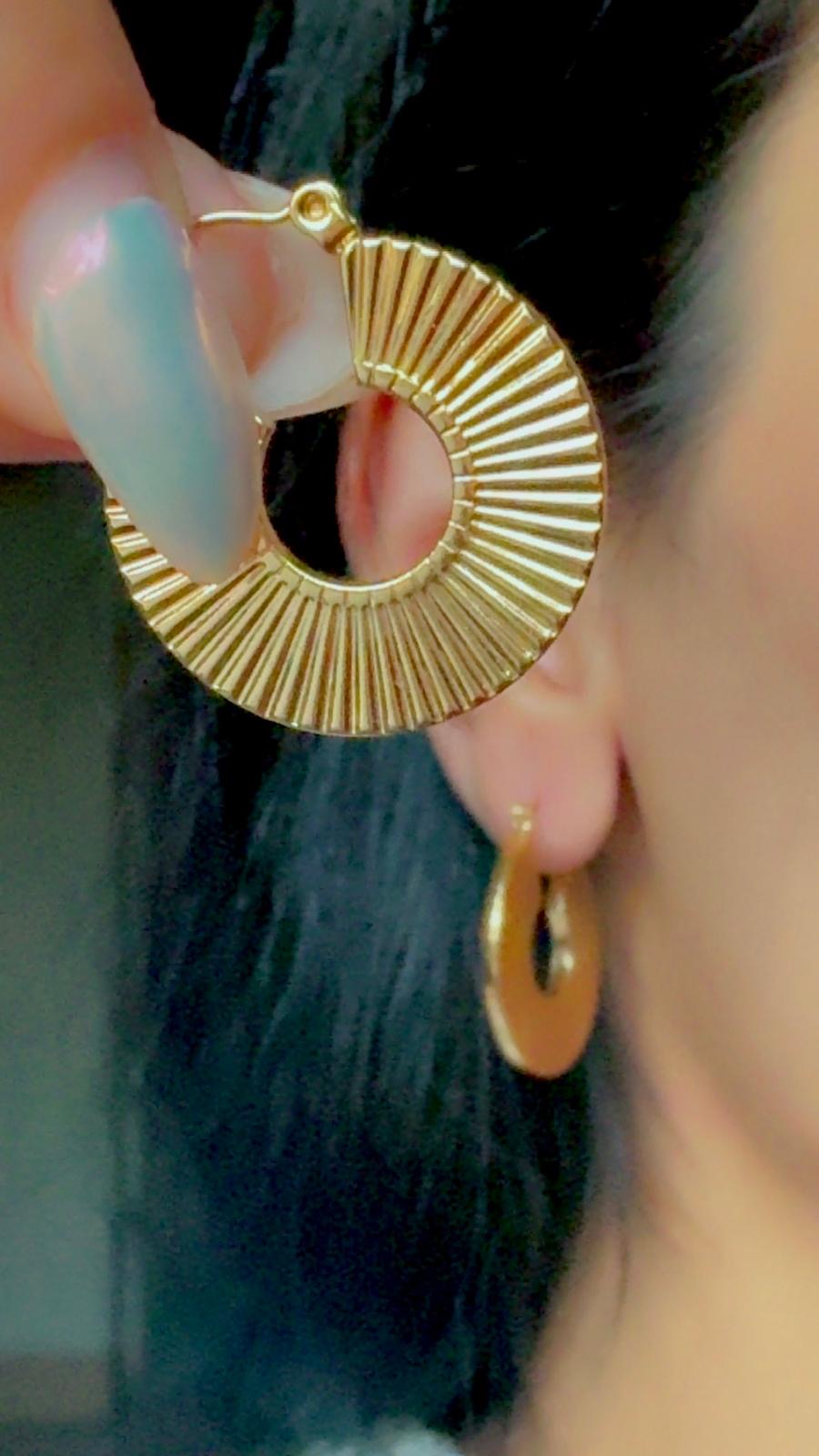 Close-up of gold textured hoop earrings in 18K gold-plated stainless steel, non-tarnish, waterproof, and hypoallergenic design worn on ear