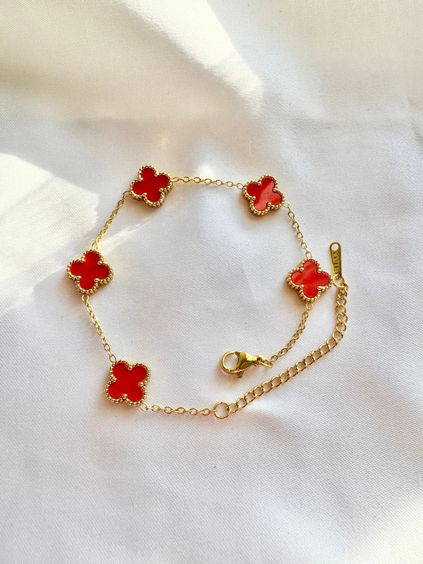Gold bracelet with red clover charms