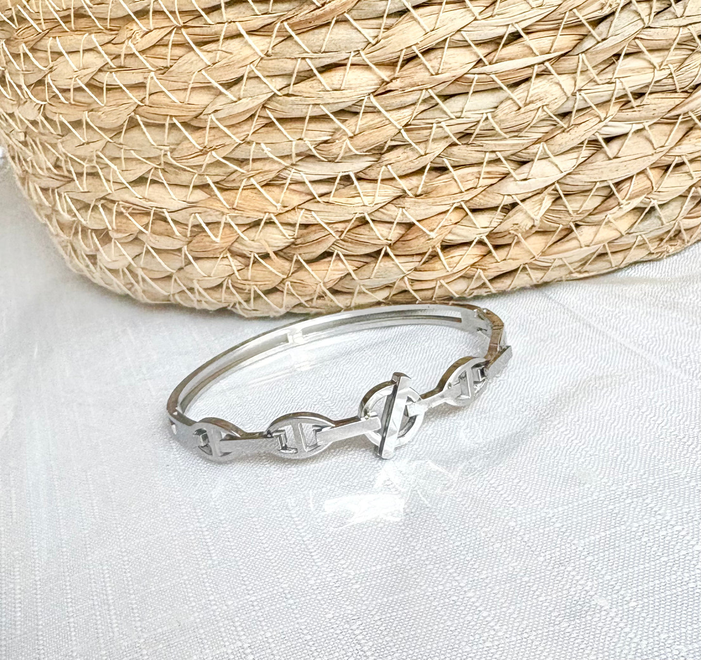 Silver bracelet on a white fabric background