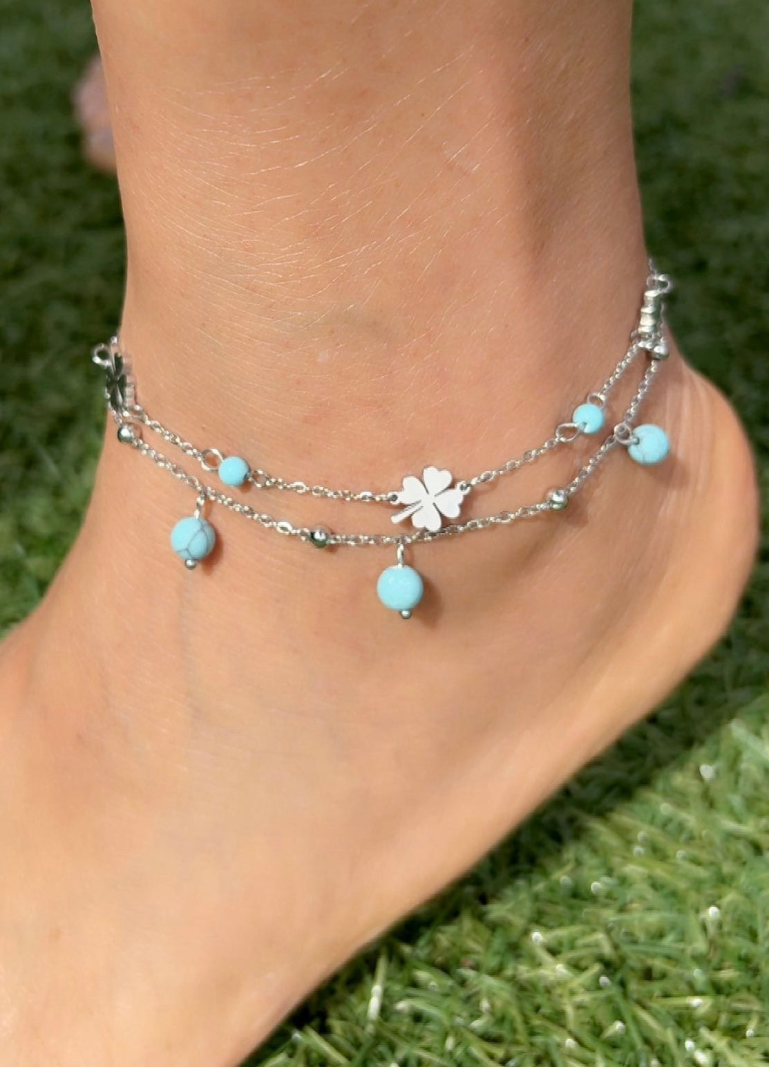 Ankle bracelet with blue beads and a clover charm