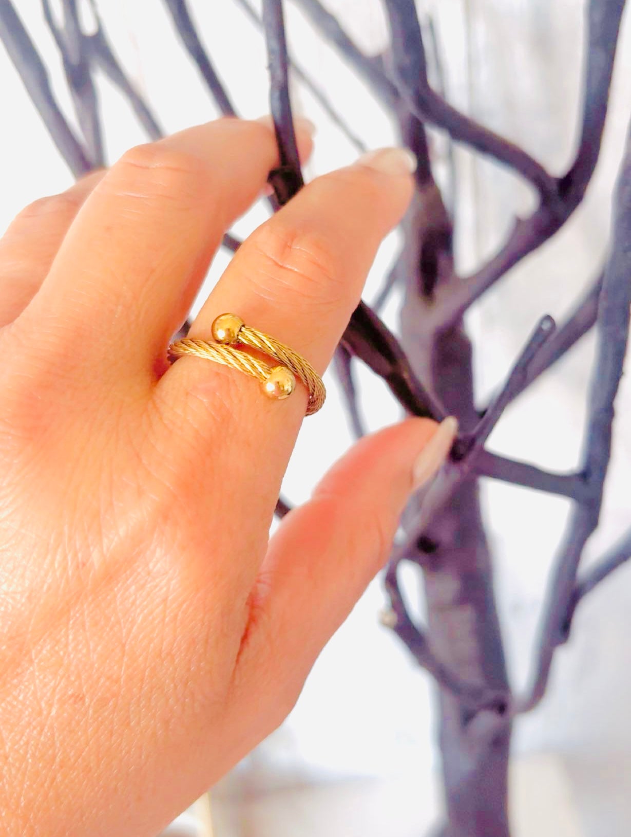 Modern gold ring with rope texture and ball end details