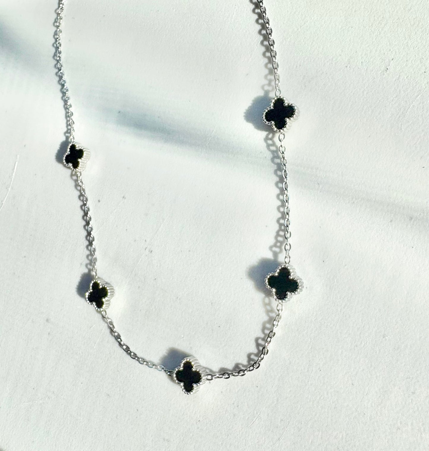 Silver 5-clover necklace with black clover charms on a stainless steel chain (42–46 cm)