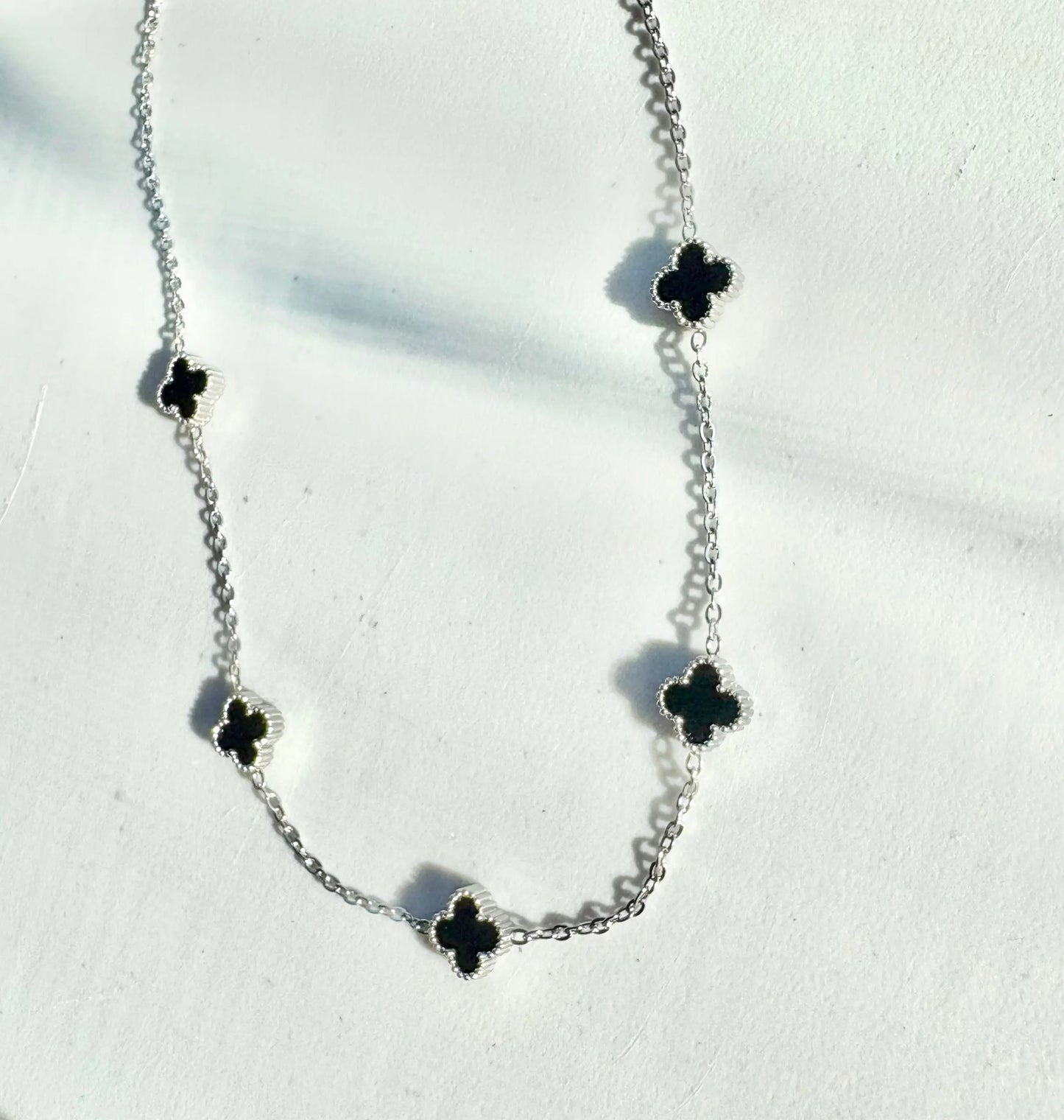 Silver 5-clover necklace with black clover charms on a stainless steel chain (42–46 cm)