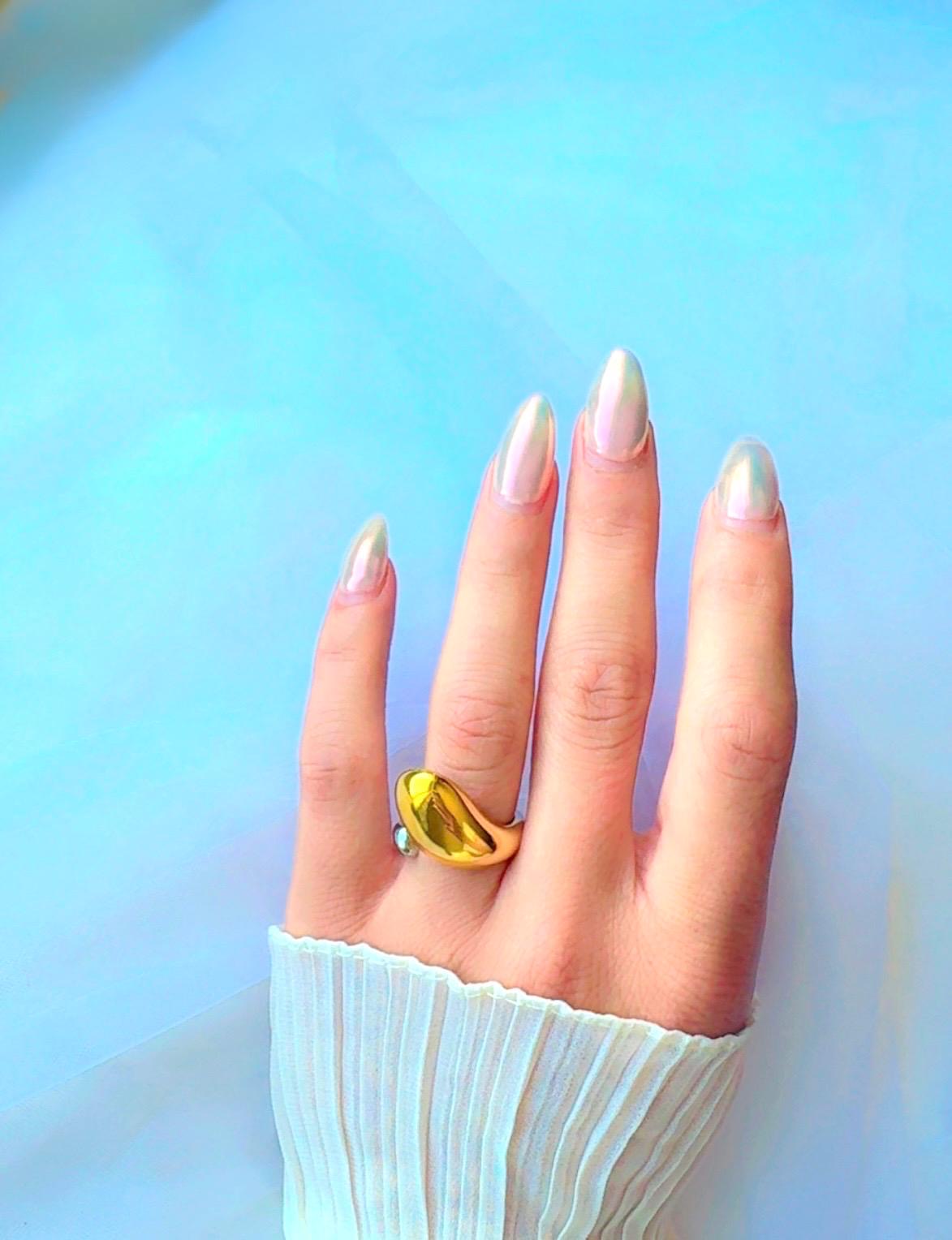 Two-tone abstract dome ring with silver band and gold dome accent on textured background