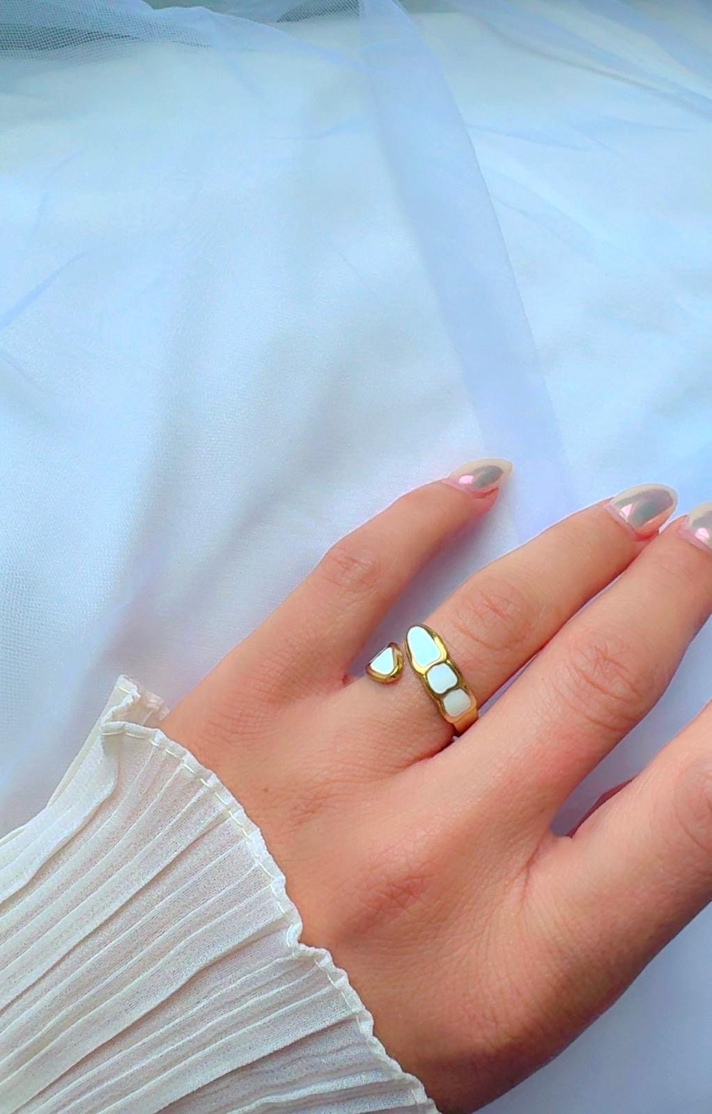 Close-up of gold open band ring with glossy shell-like design, size 7