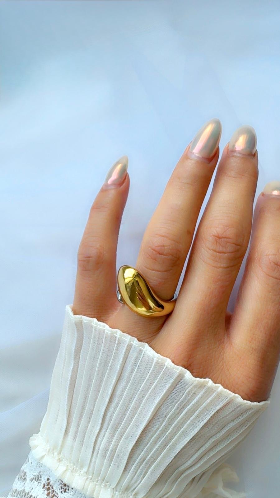 Gold ring on a hand with a light background