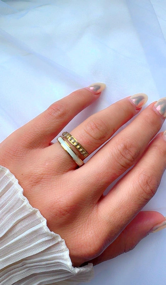Gold plated adjustable ring with cubic zirconia stones on stone background