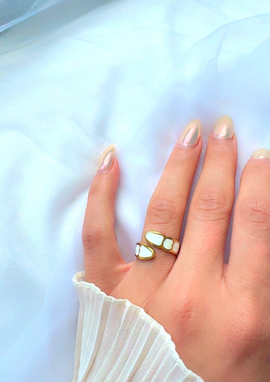 Gold open band ring with white shell-inspired inlay displayed on hand