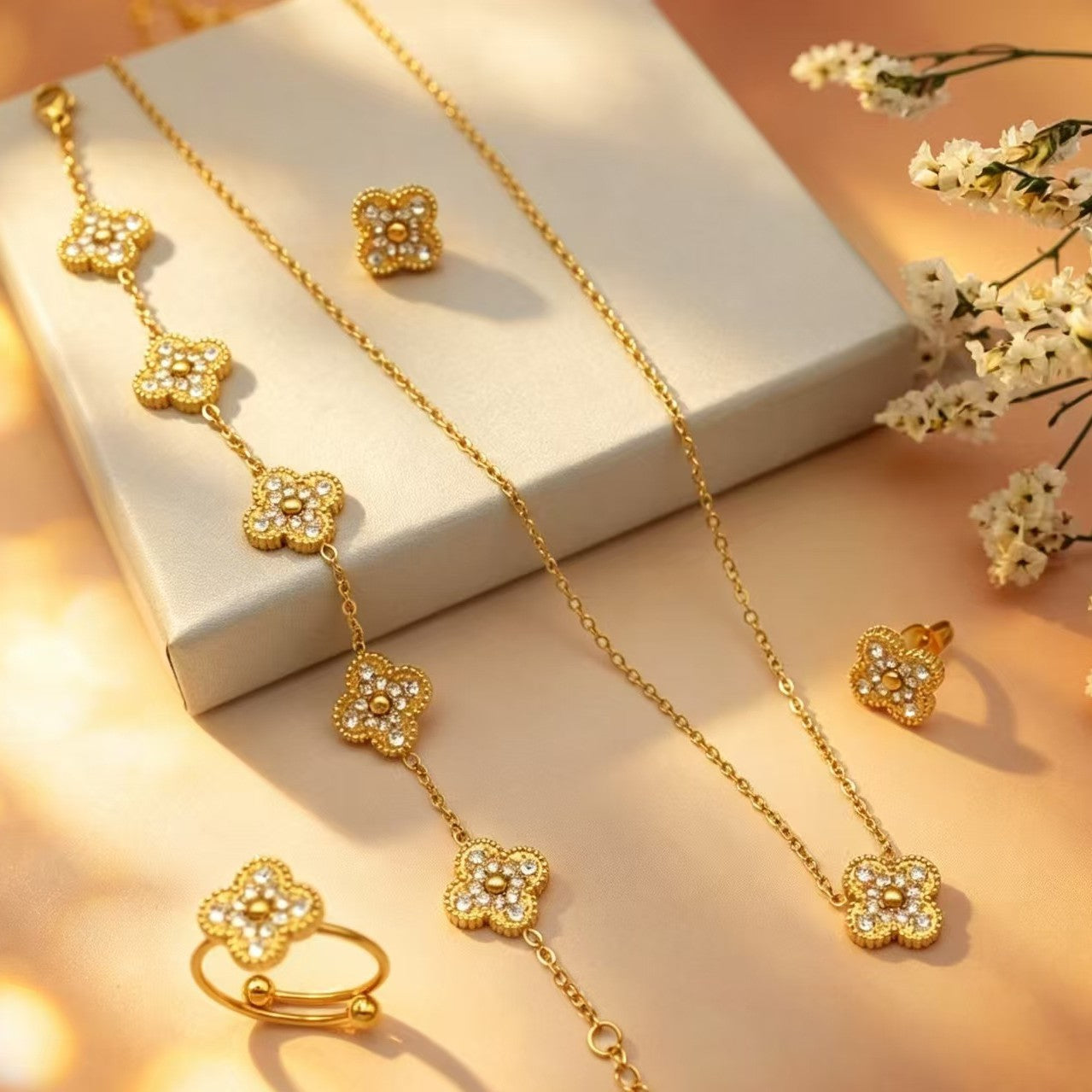 Gold jewelry set with necklace, earrings, and ring on a soft background