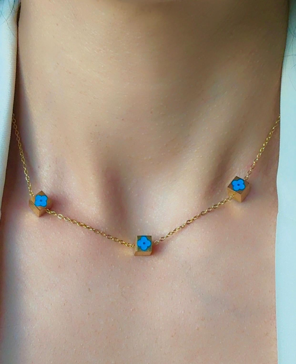 Gold necklace with blue stones on a person's neck
