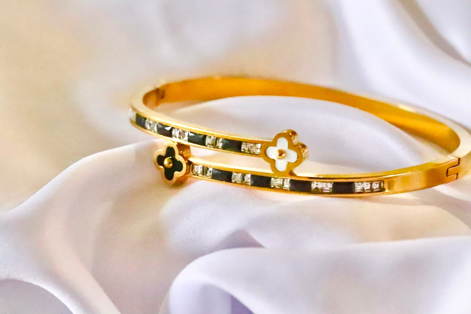 Gold bangle with zircon stones on a white fabric