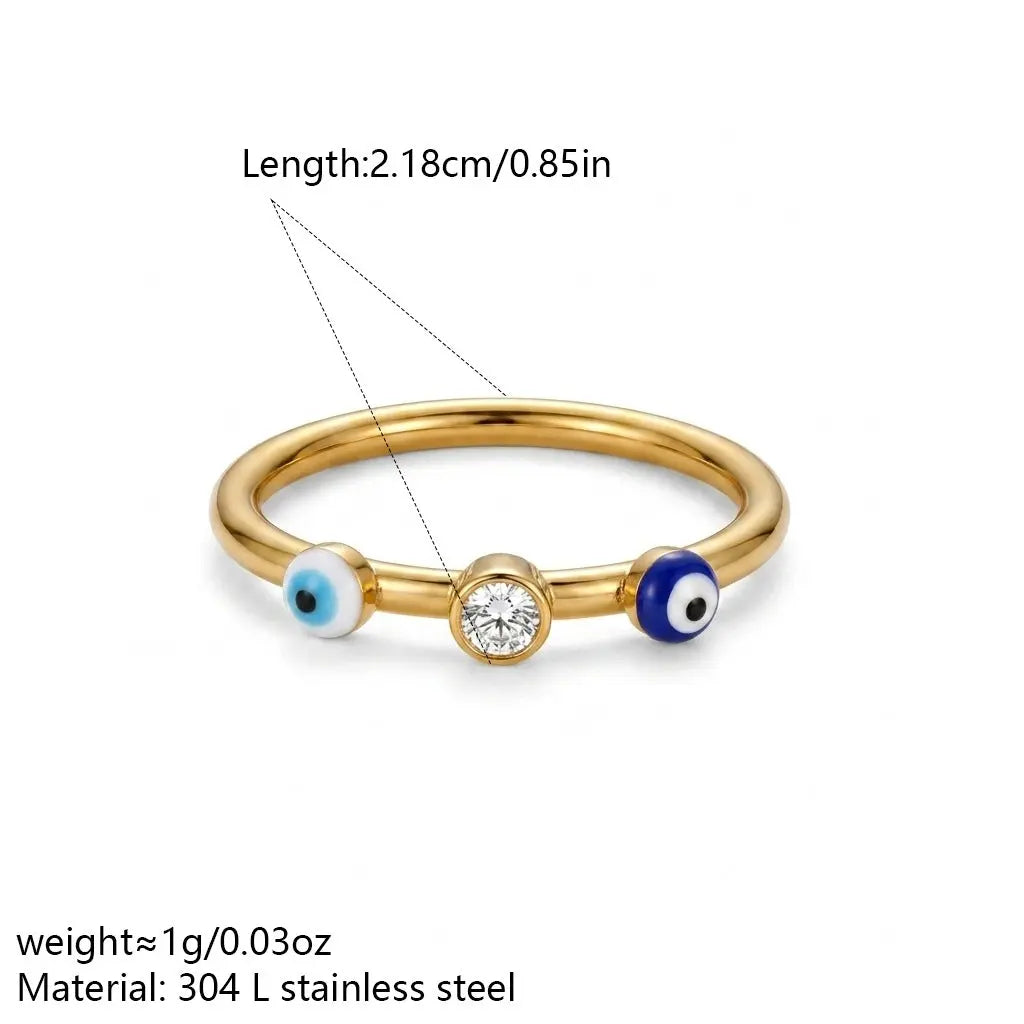 18K gold-plated slim ring with two blue-and-white evil eye details and a bezel-set clear zircon centre