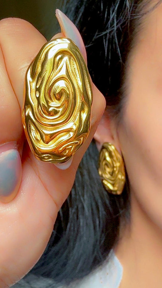 Bold textured gold statement earrings with swirl design displayed on ear
