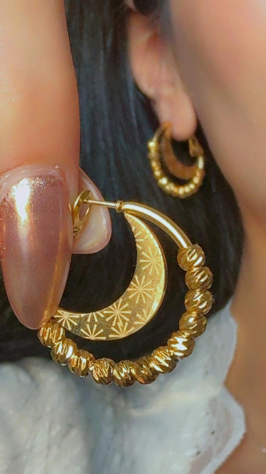 Gold crescent moon hoop earrings with textured bead accents displayed on ear
