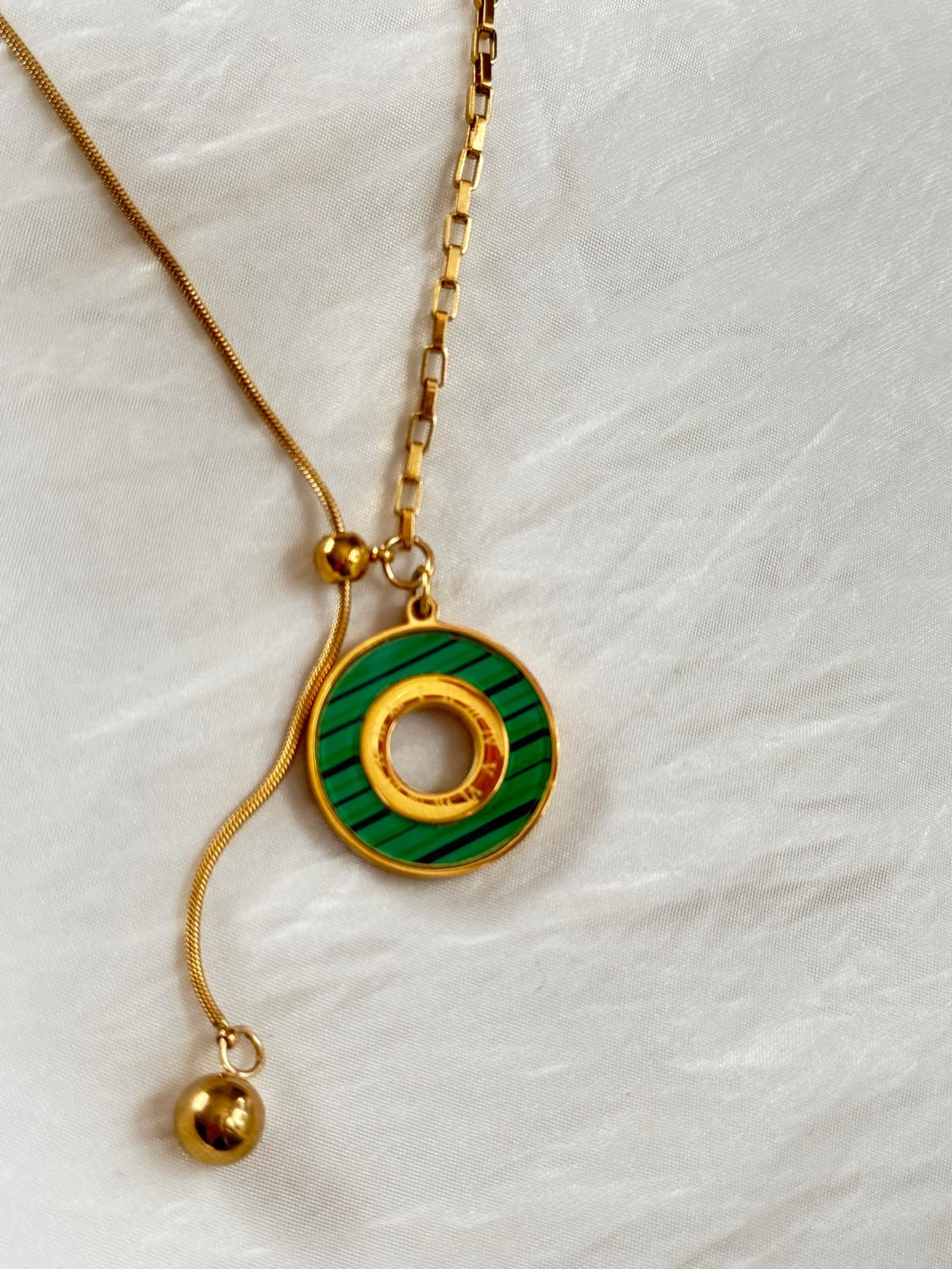 Necklace with a green and gold pendant on a white background