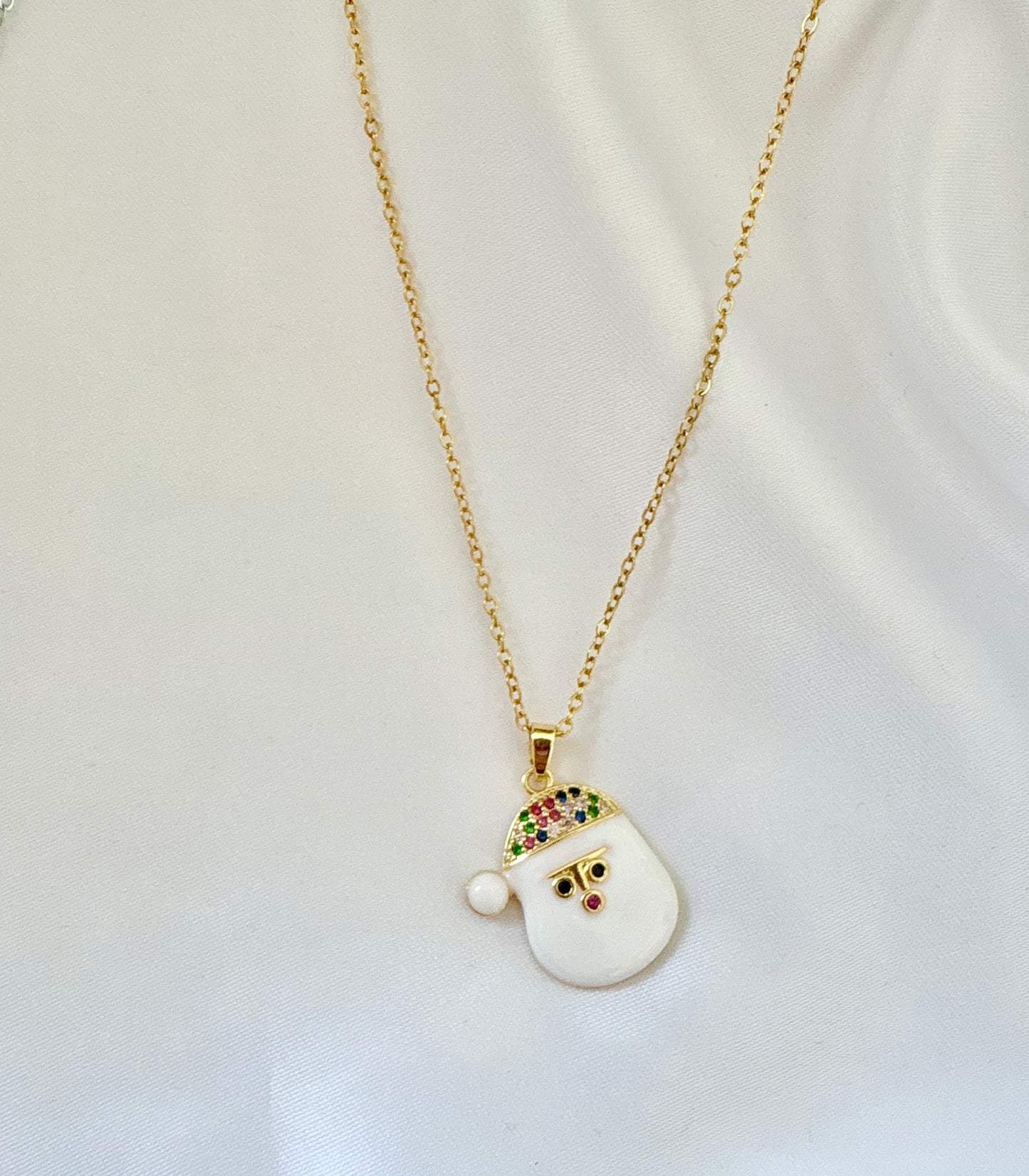 Necklace with a white pendant featuring colorful gemstones on a light background.