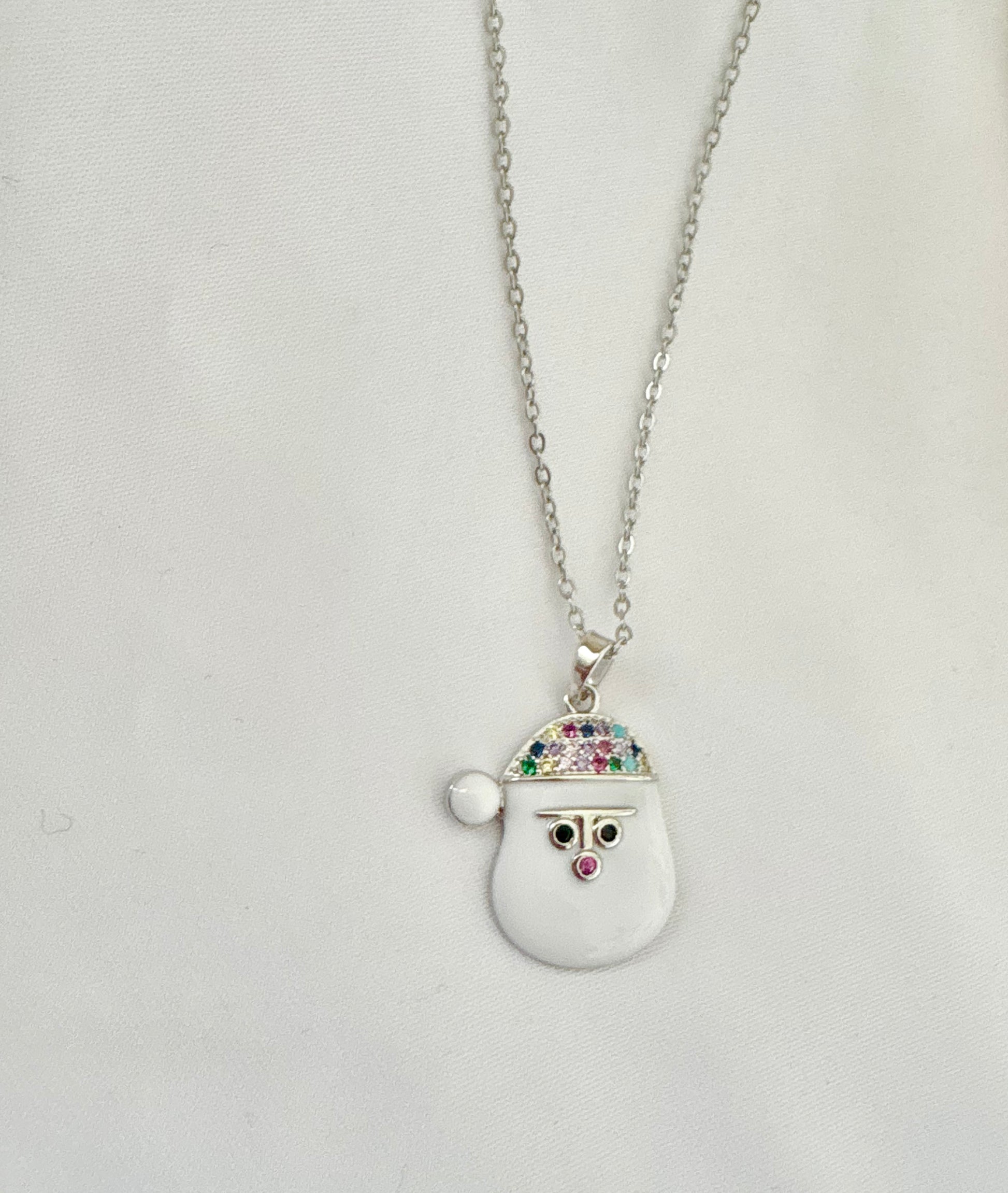 Necklace with a snowman pendant on a light gray background.