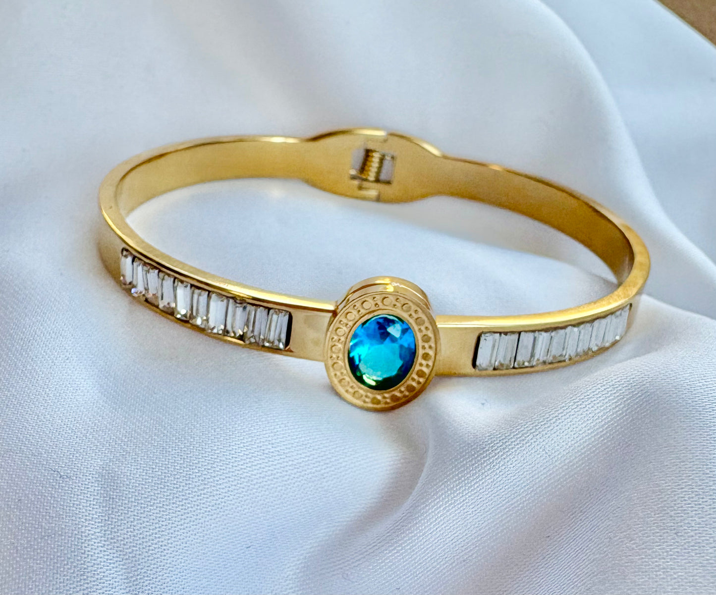 Gold bracelet with a blue gemstone and zircon stones 