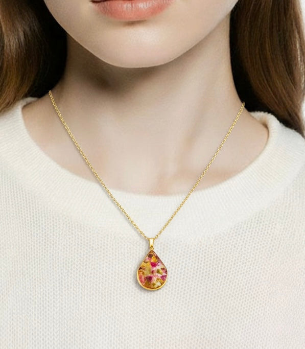 Necklace with a teardrop-shaped pendant worn by a person on a white background