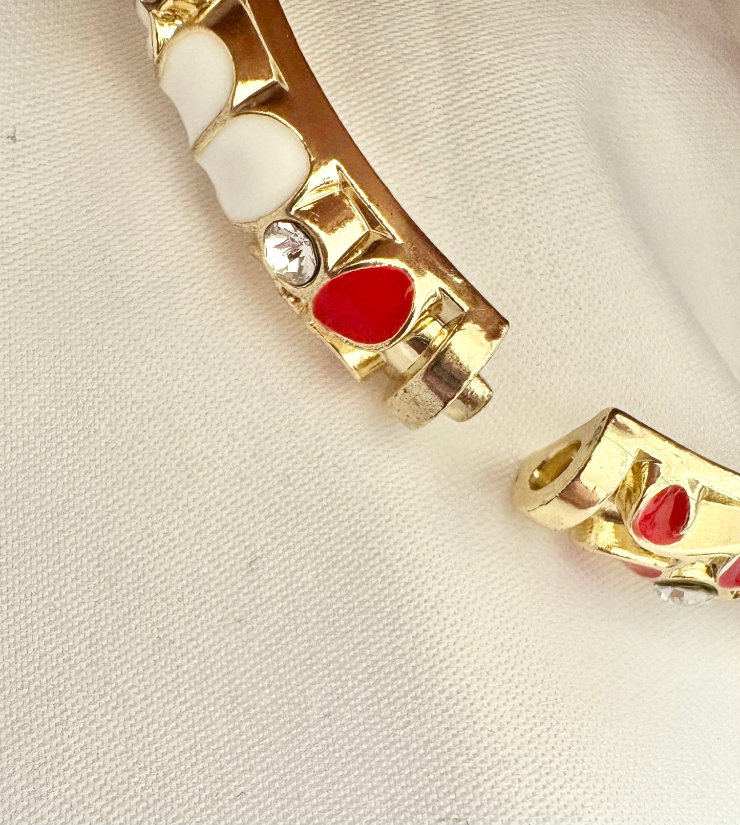 Gold bracelet with red and white blossom showing the closure