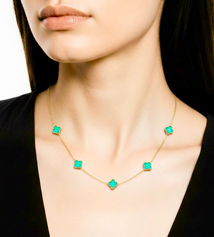 Necklace with turquoise clover worn by a person against a neutral background