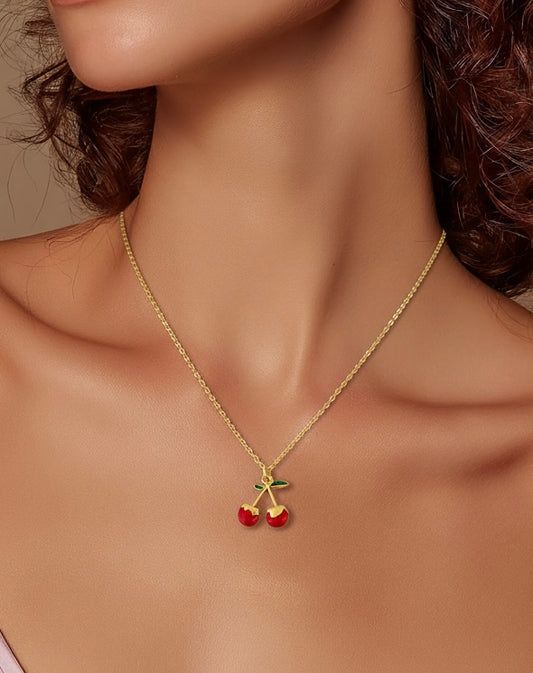 Playful gold cherry necklace displayed on mannequin