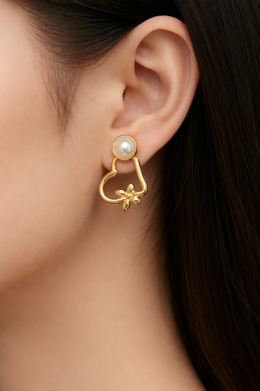 Gold earring with pearl detail worn by a person