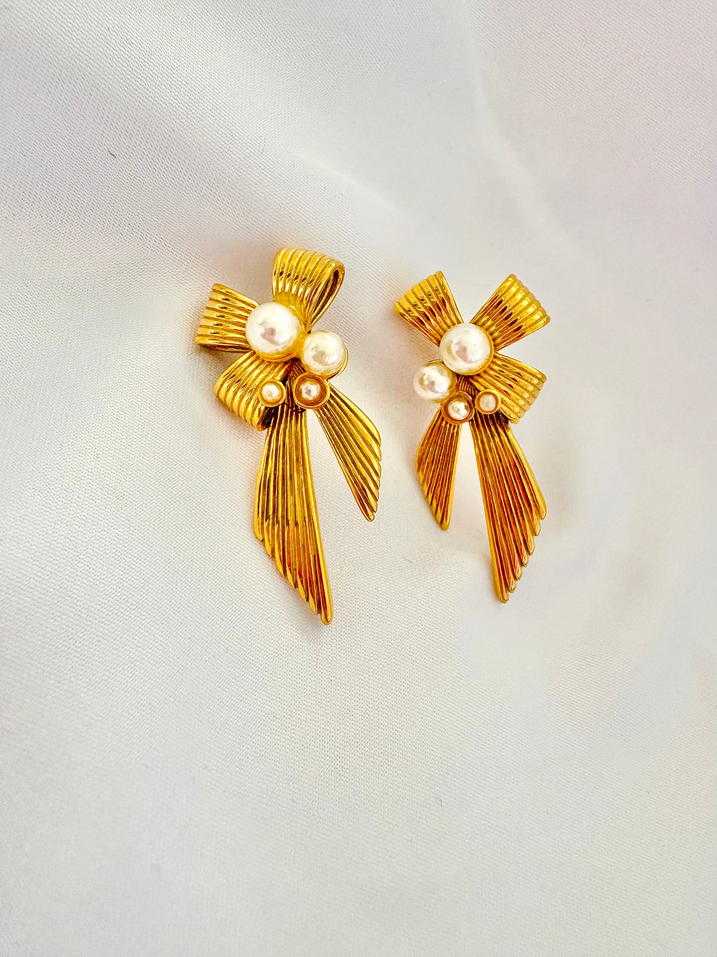 Elegant ribbon bow pearl earrings on white background