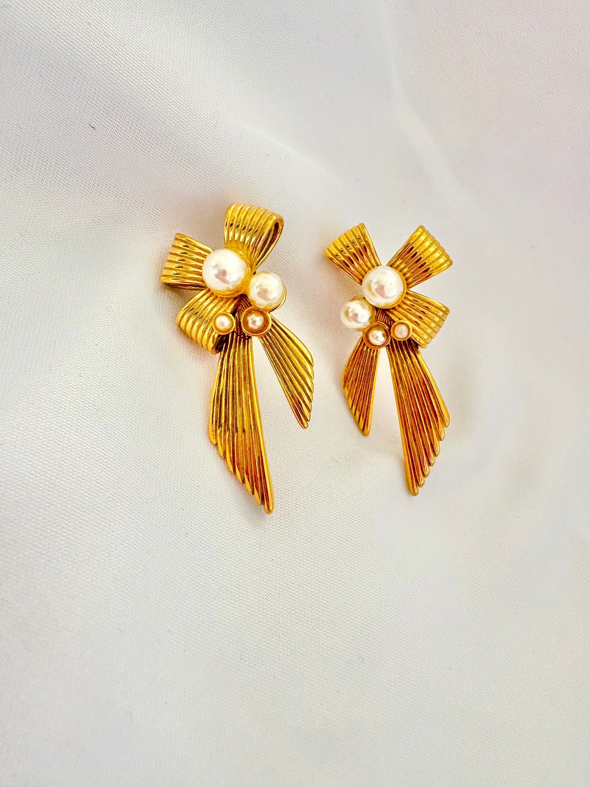 Elegant ribbon bow pearl earrings on white background