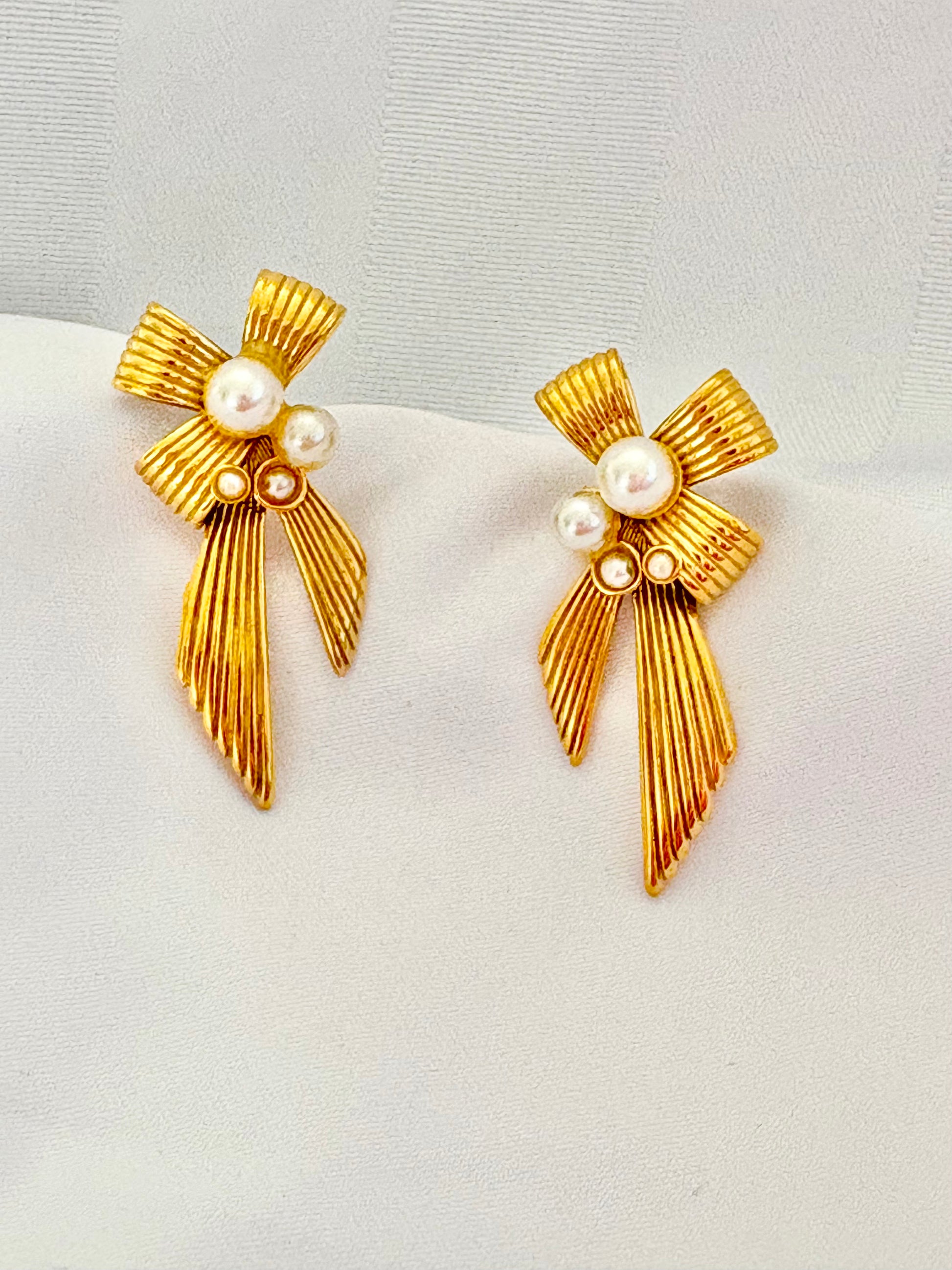 Textured gold bow earrings with pearl accents