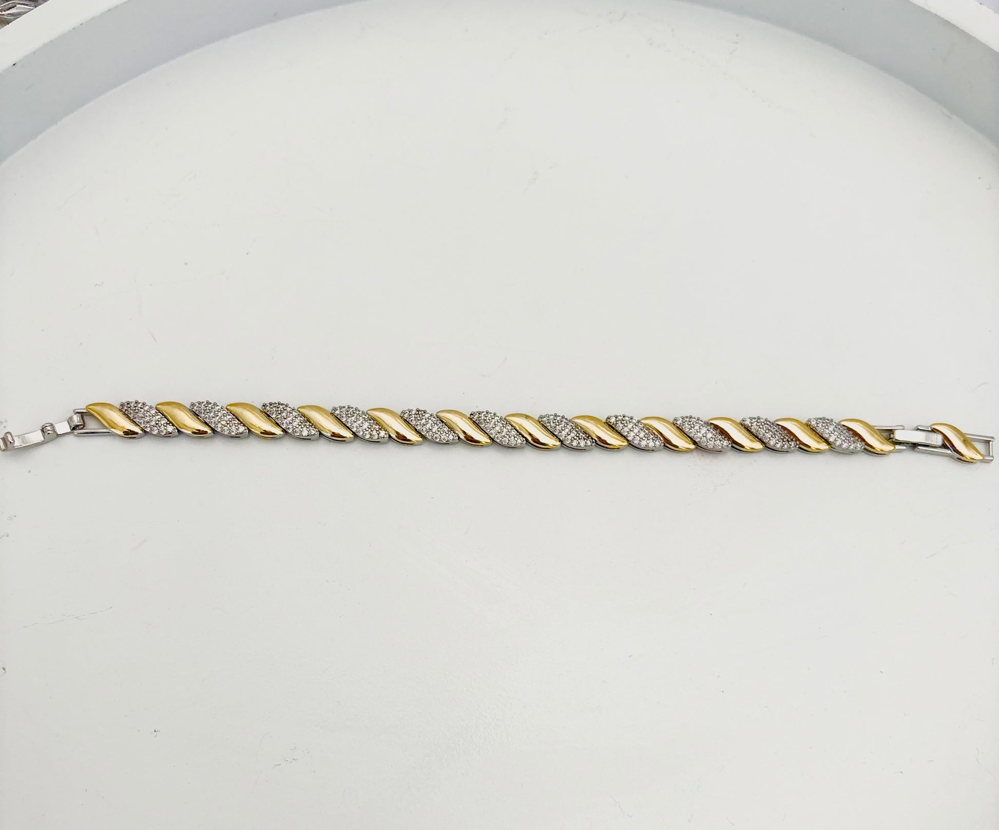 Gold and silver braided bracelet on a light gray background