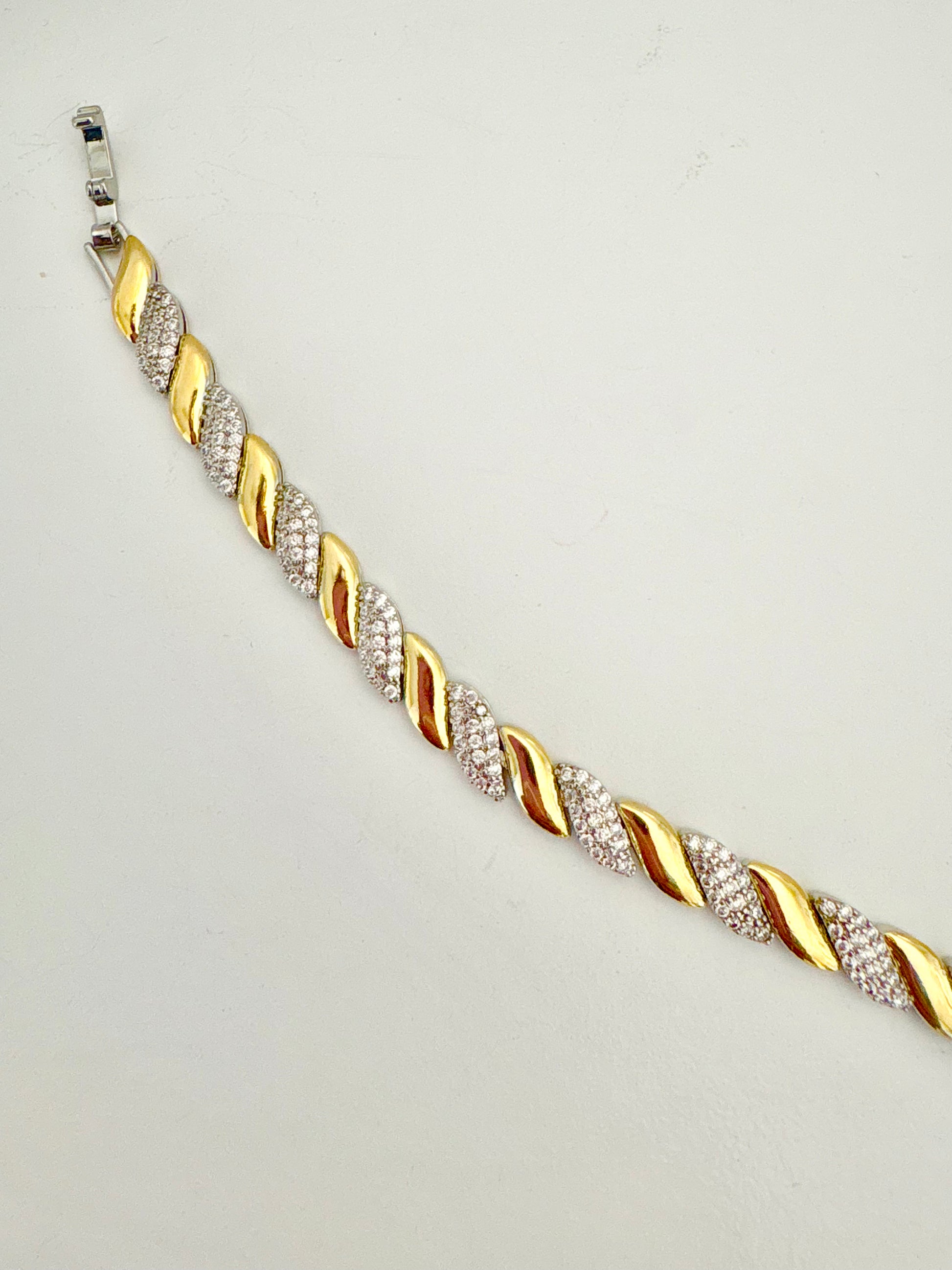 Gold and silver bracelet on a light gray background