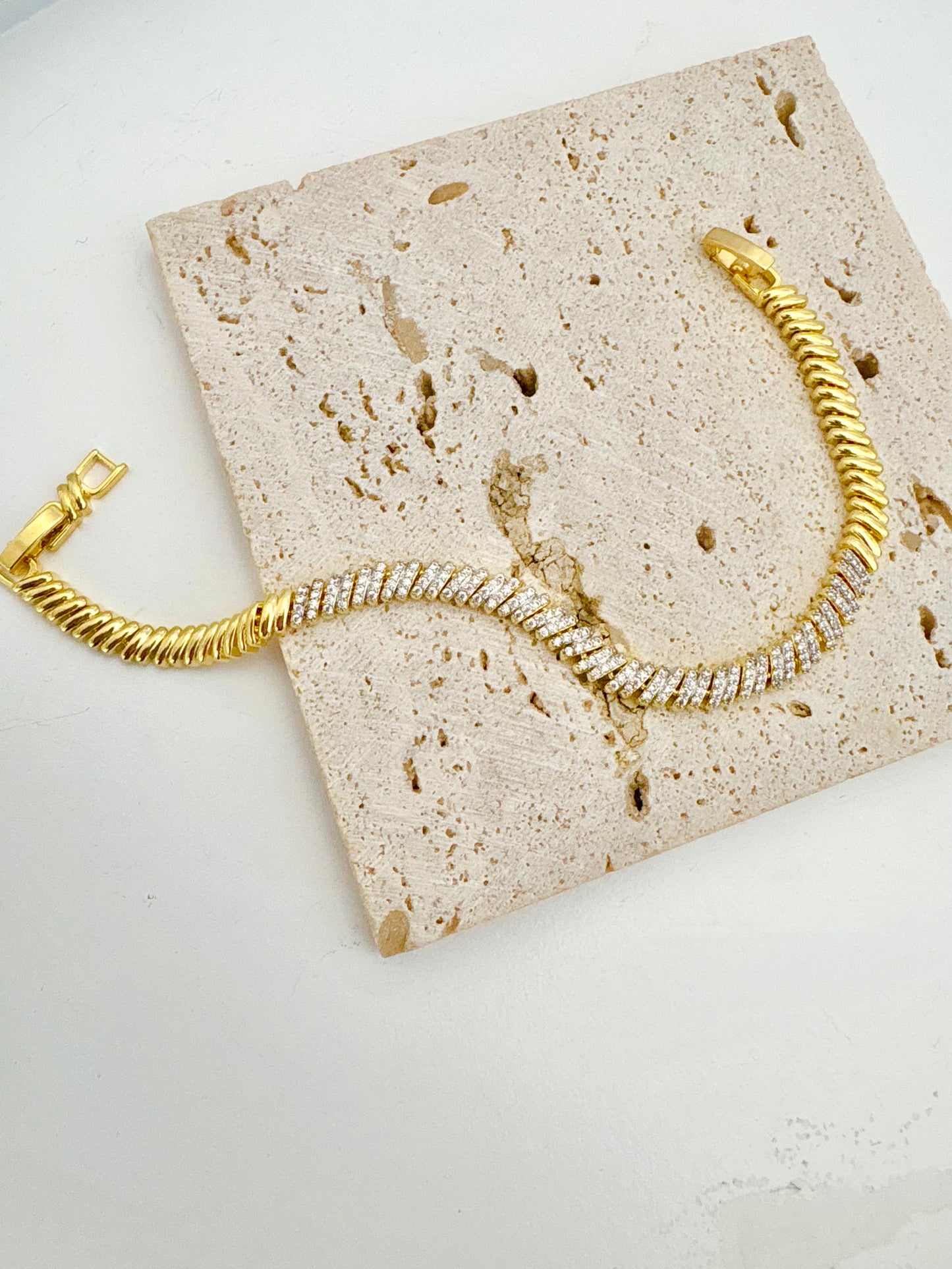 Gold bracelet with zircon stones a textured stone surface