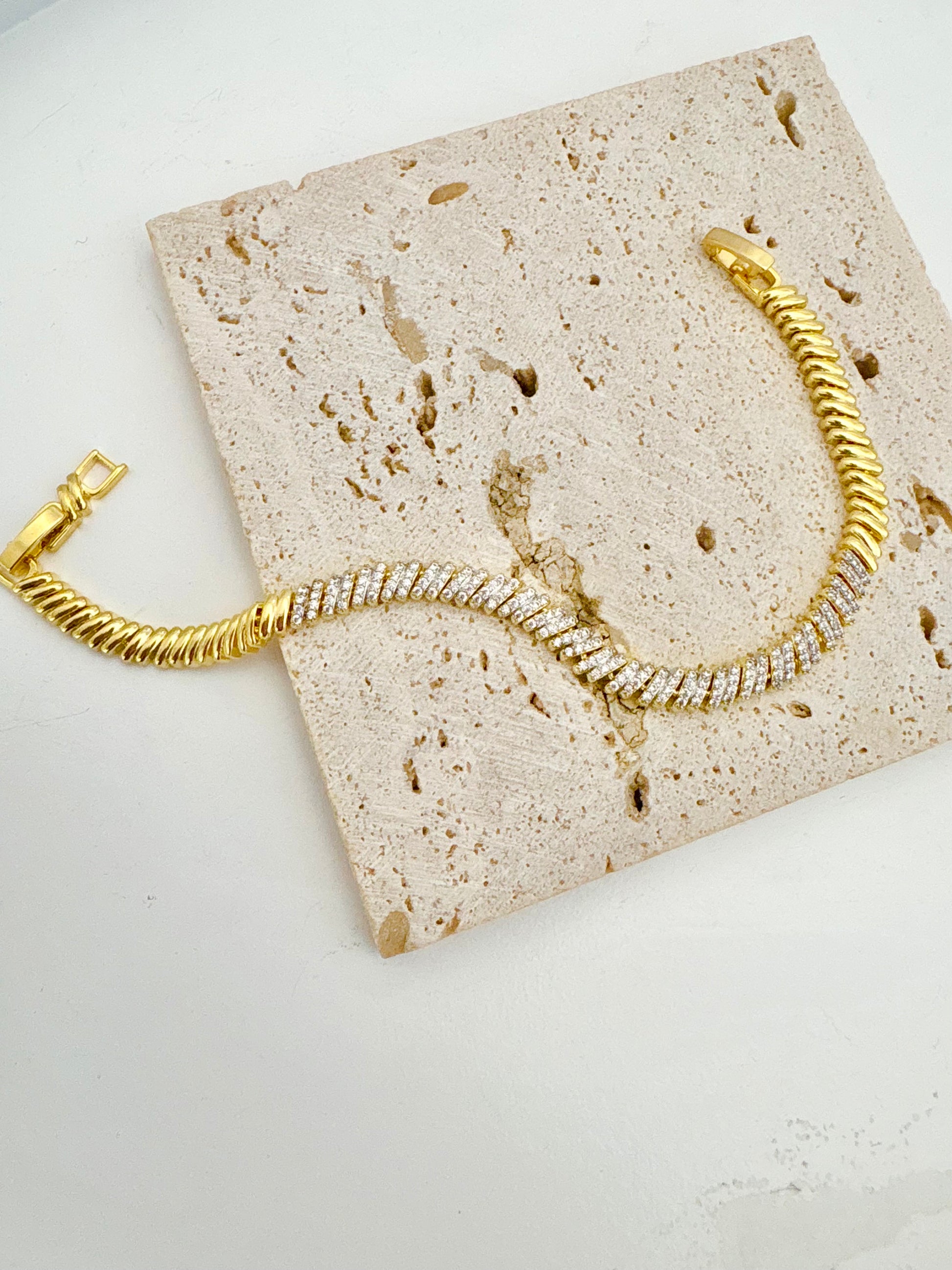 Gold bracelet with zircon stones a textured stone surface