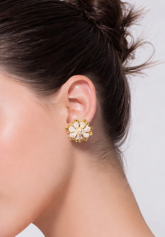 Close-up of a woman's ear wearing a floral earring with a white background