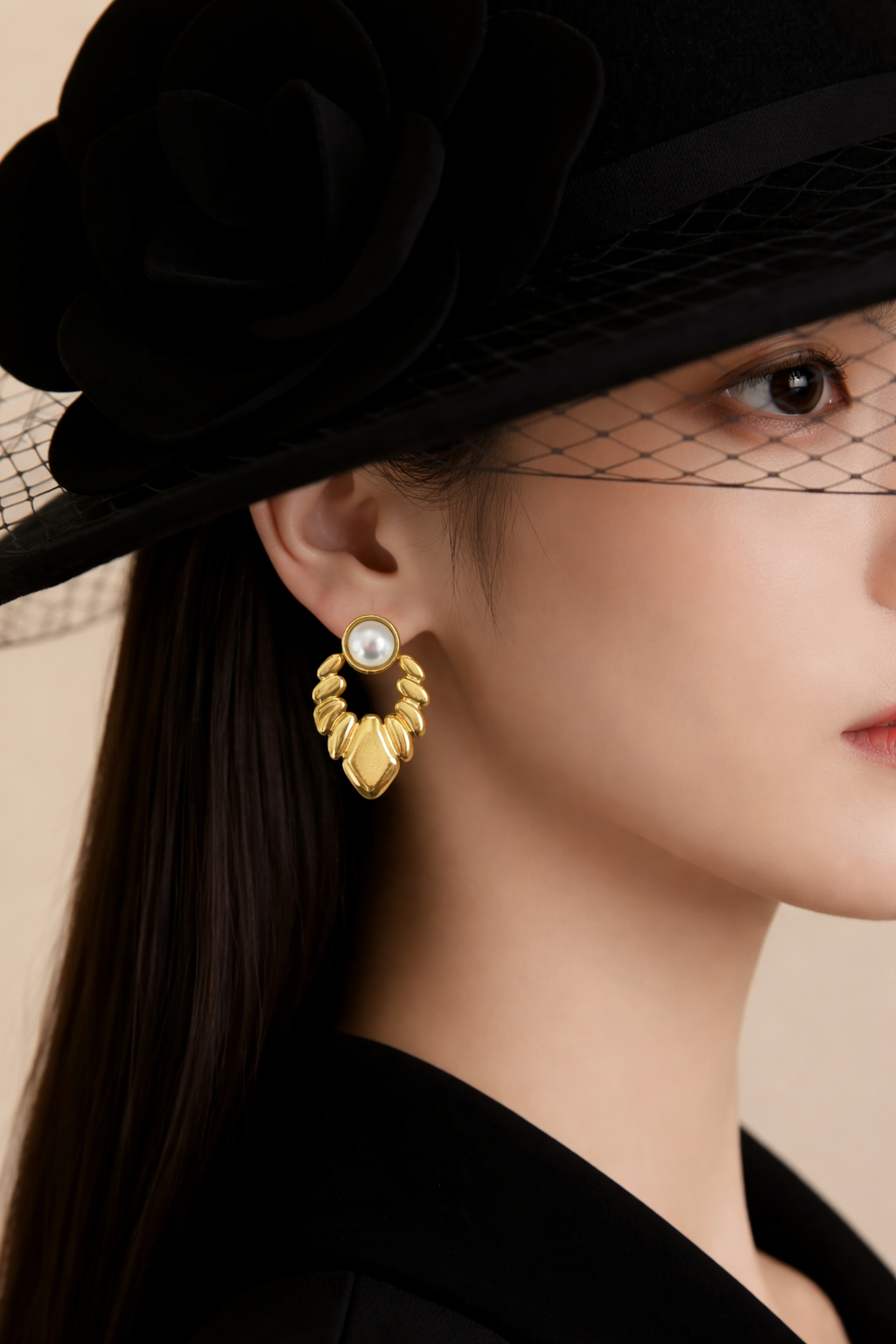 Close-up of a person wearing gold earrings and a black hat with a veil.