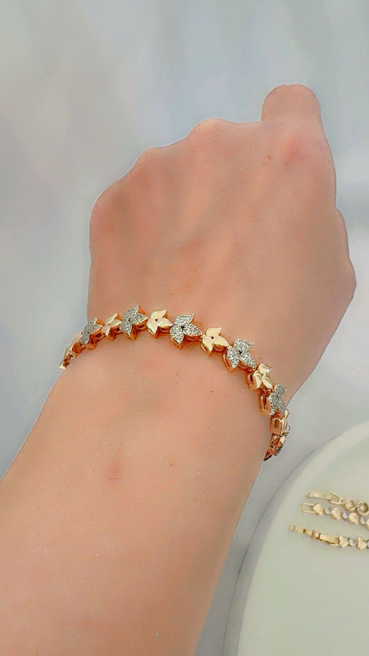Gold bracelet with zircon on a wrist against a light white background