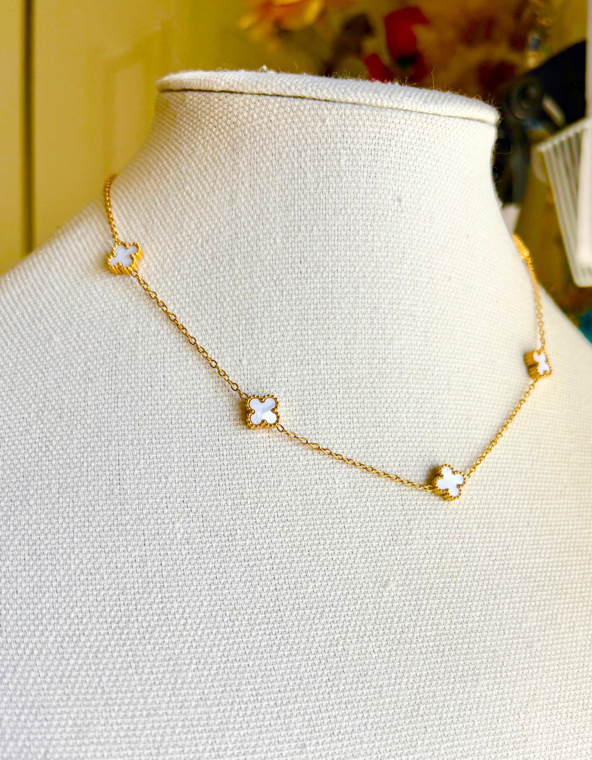 Gold necklace with clover pendants on a mannequin