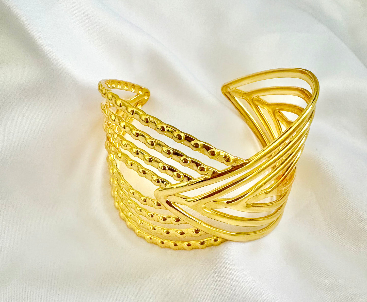 Gold cuff on a white fabric background