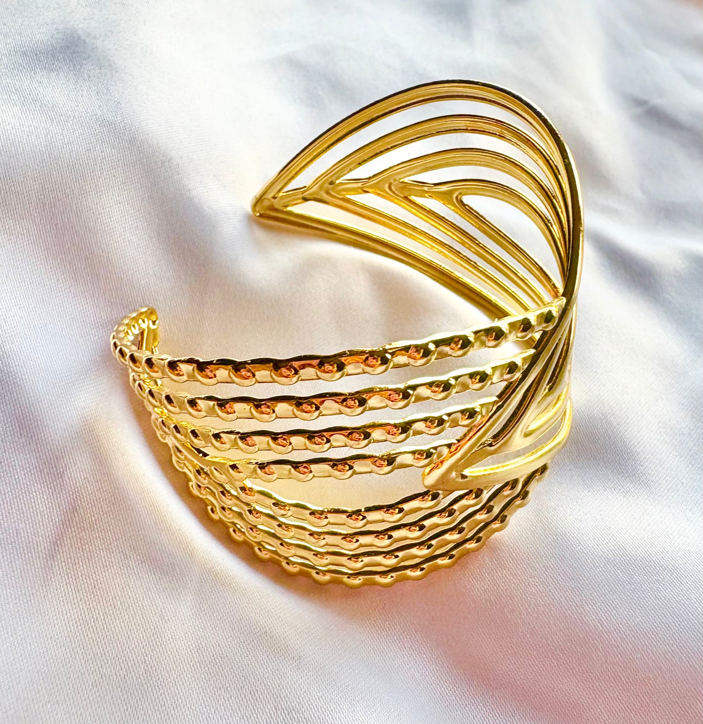 Gold bangle on a white fabric background