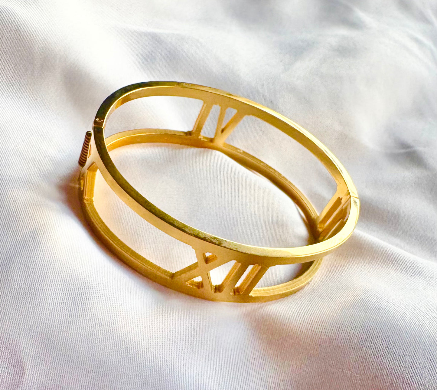 Gold bracelet on a white fabric background