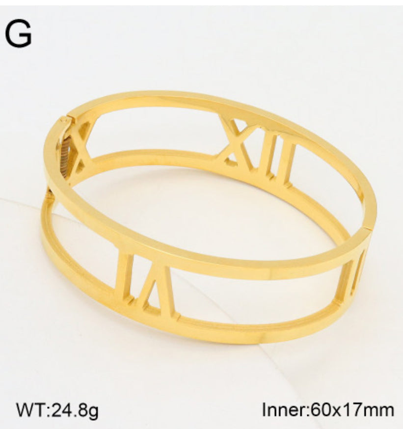 Gold bracelet with Roman numeral design on a white background