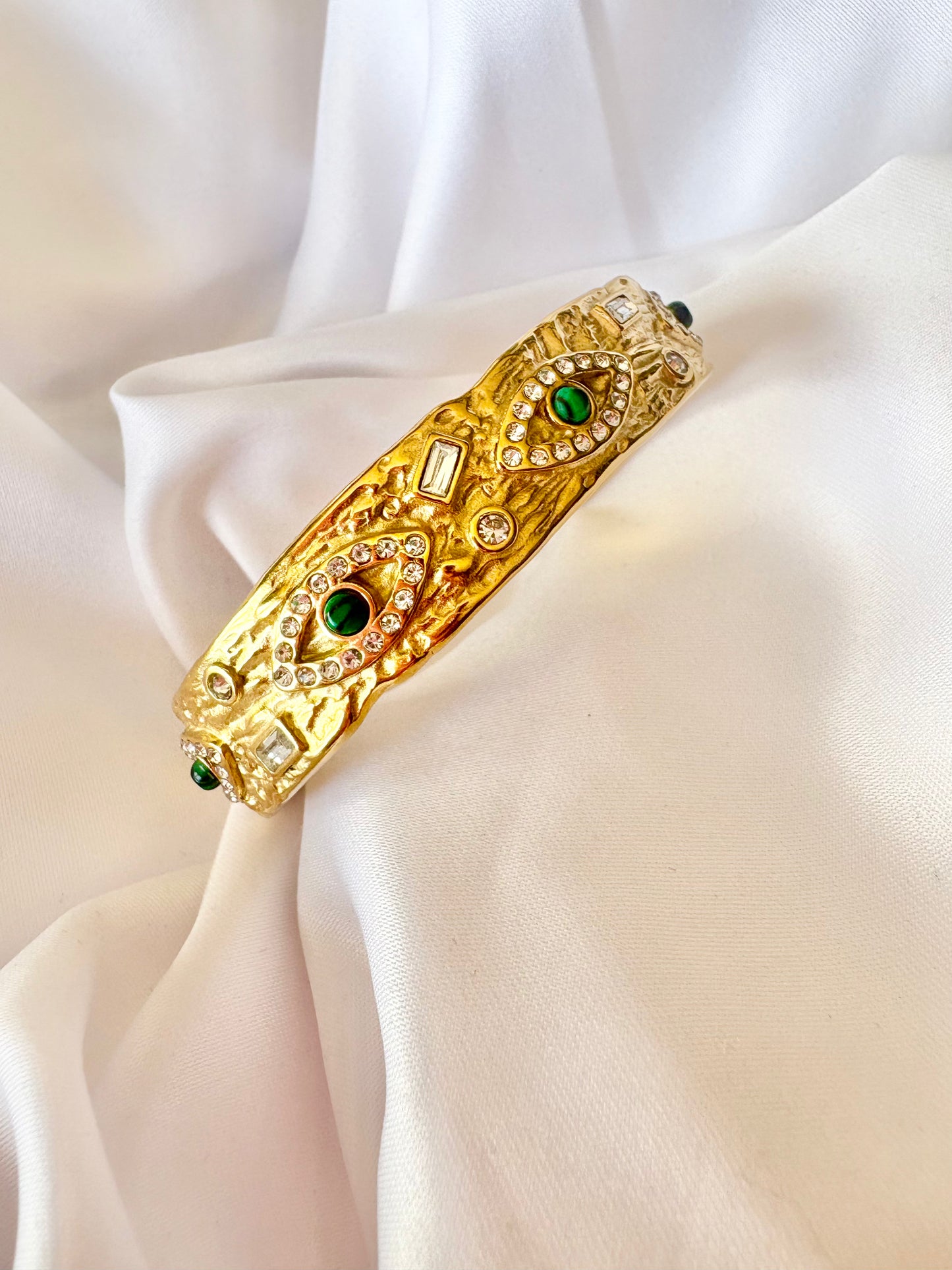 Gold bracelet with green gemstones