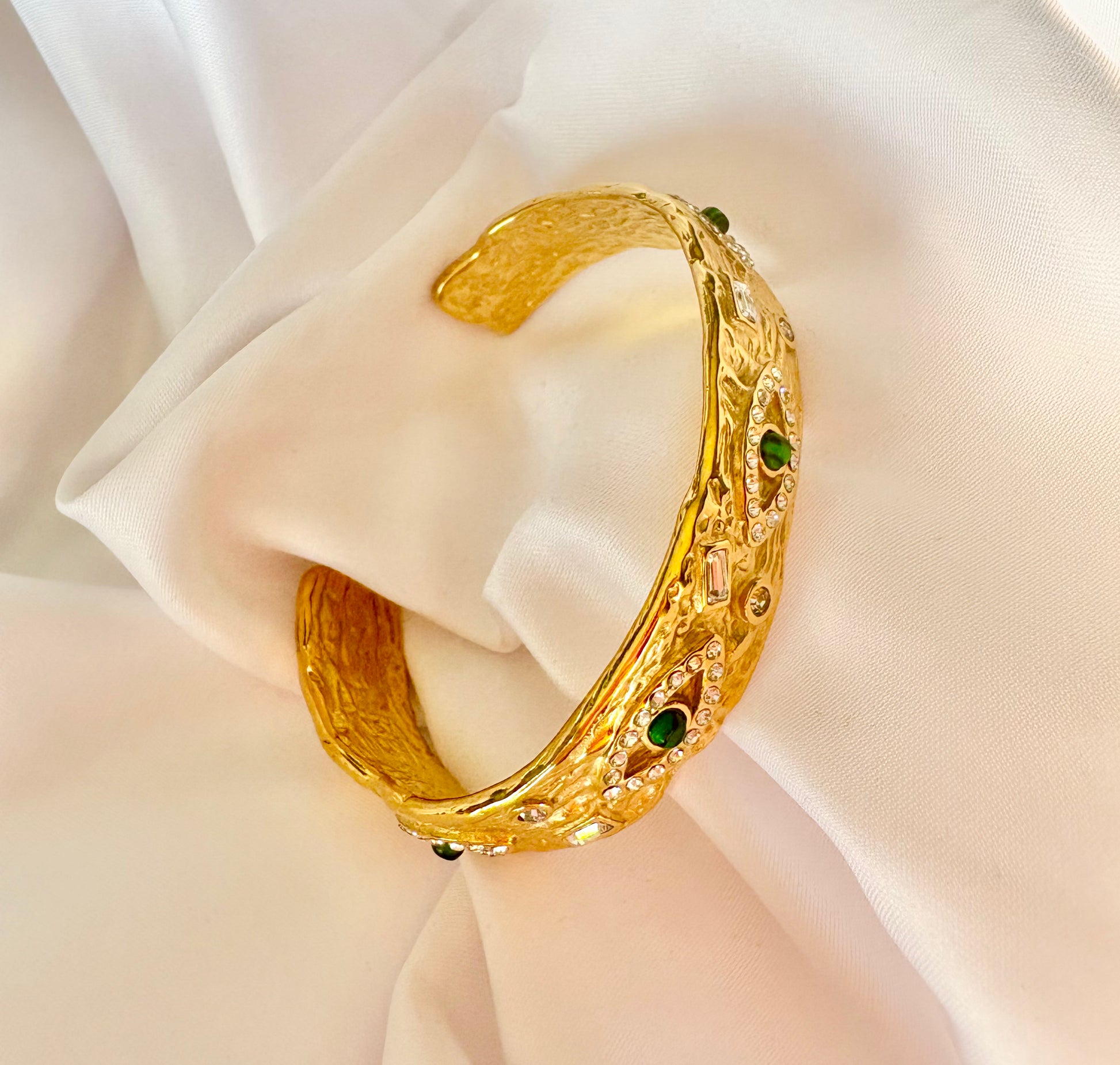 Gold bracelet with green gemstones