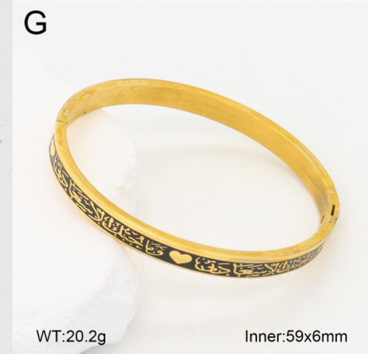 Gold bracelet with black engraving on a white background