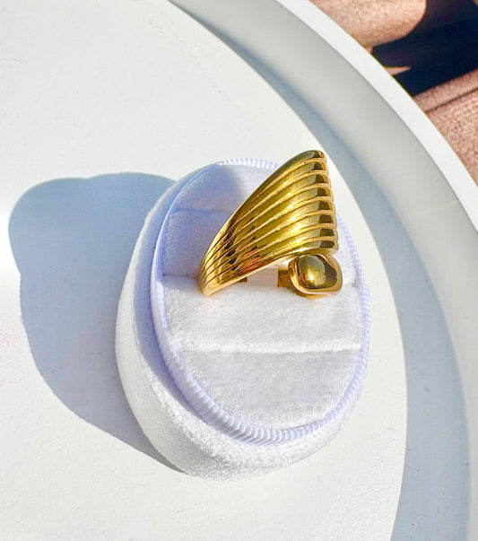 A gold ring with a sculptural, layered fan-like design