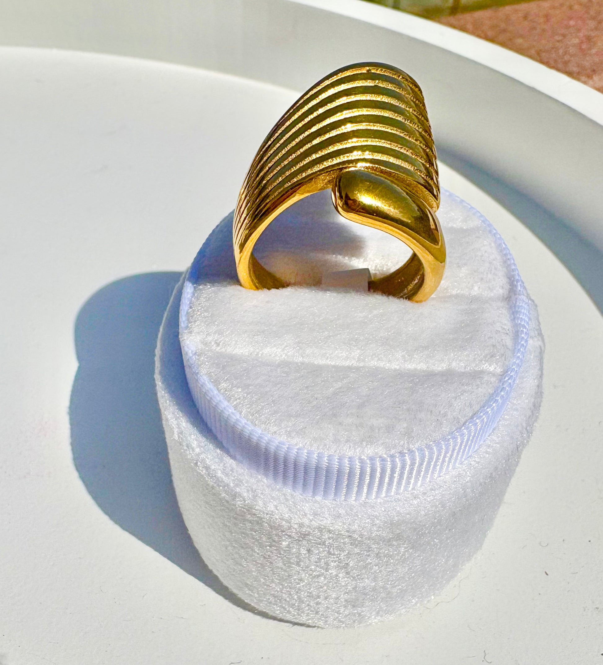 A wide, chunky gold ring with a ribbed, segmented design