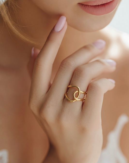 Close-up of a hand wearing a gold ring with a blurred background