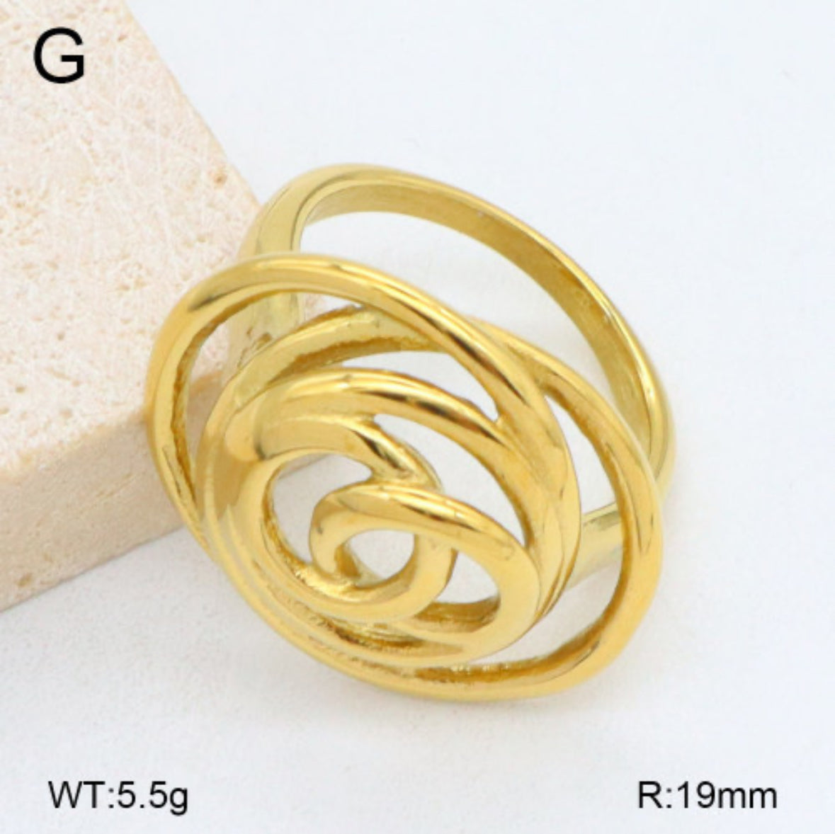Gold ring with a spiral design on a white background